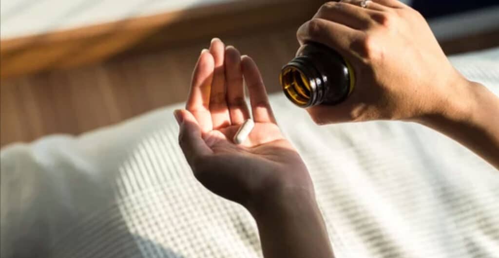 Woman hands with pills on spilling pills out of bottle,Female hand holding a medicine
