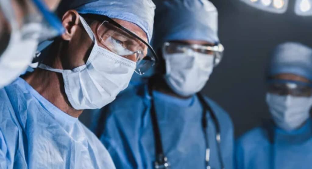 Concentrated surgeons operating patient in operating theatre. Healthcare workers concept.
