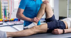 Physiotherapist working with young male patient in the rehabilitation center